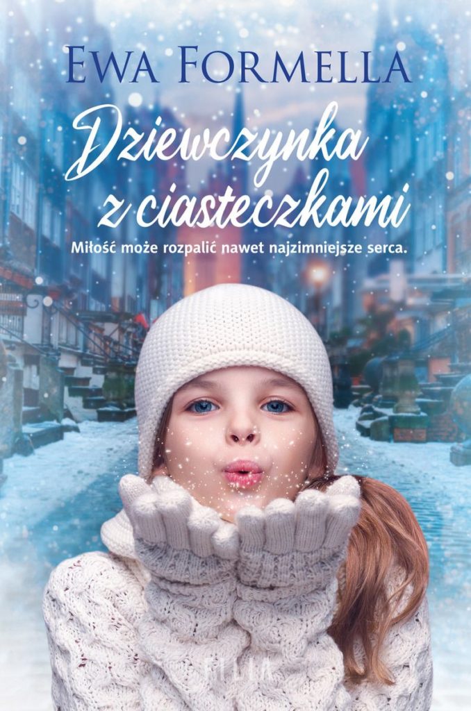 Na okładce ubrana w białą czapkę, rękawiczki i sweter dziewczynka, która zdmuchuje z rąk płatki śniegu. W tle budynki i ulica w śniegu