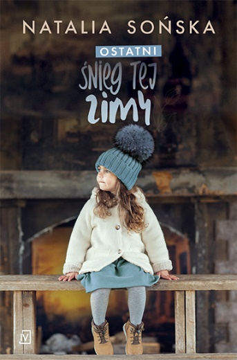 Na okładce ubrana w zimową czapkę z pomponem i biały płaszczyk dziewczynka siedzi na ławce z głową odwróconą na lewo.