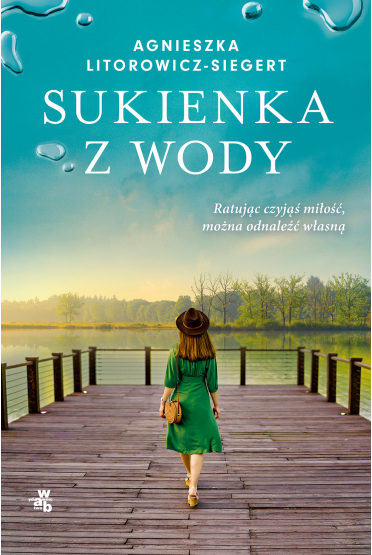 Na okładce kobieta w zielonej sukience, w kapeluszu idzie po drewnianym pomoście. W tle woda, drzewa i błękit nieba.