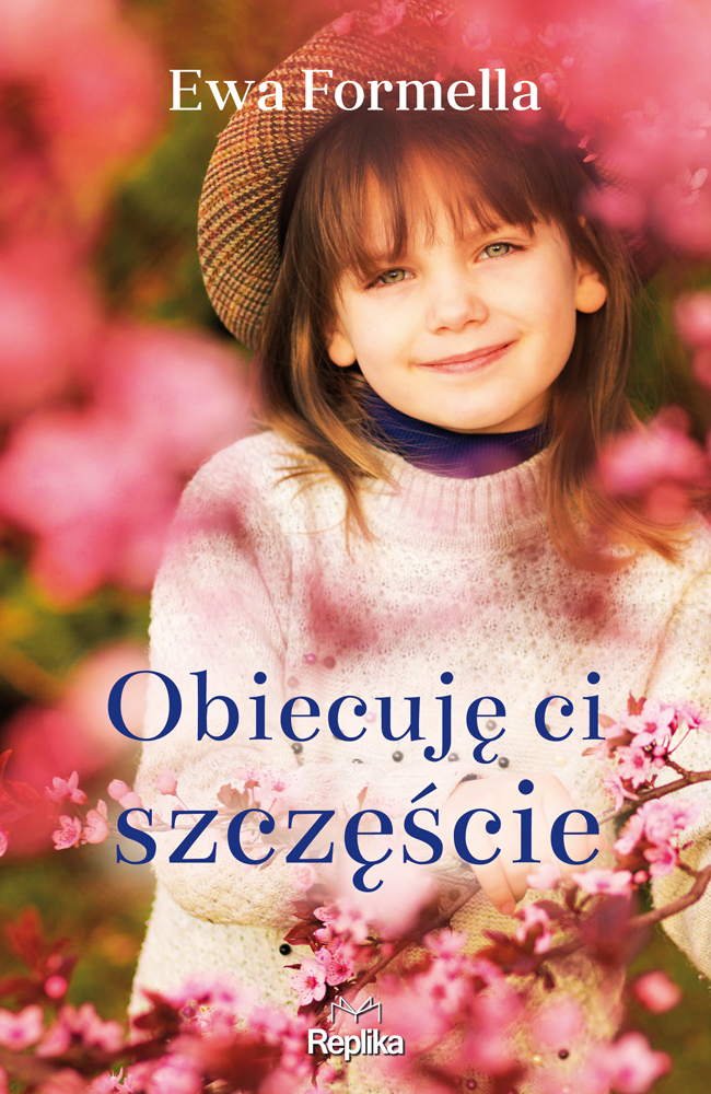 Na okładce uśmiechnięta dziewczynka w kapeluszu w białym swetrze na tle kwiatów jabłoni