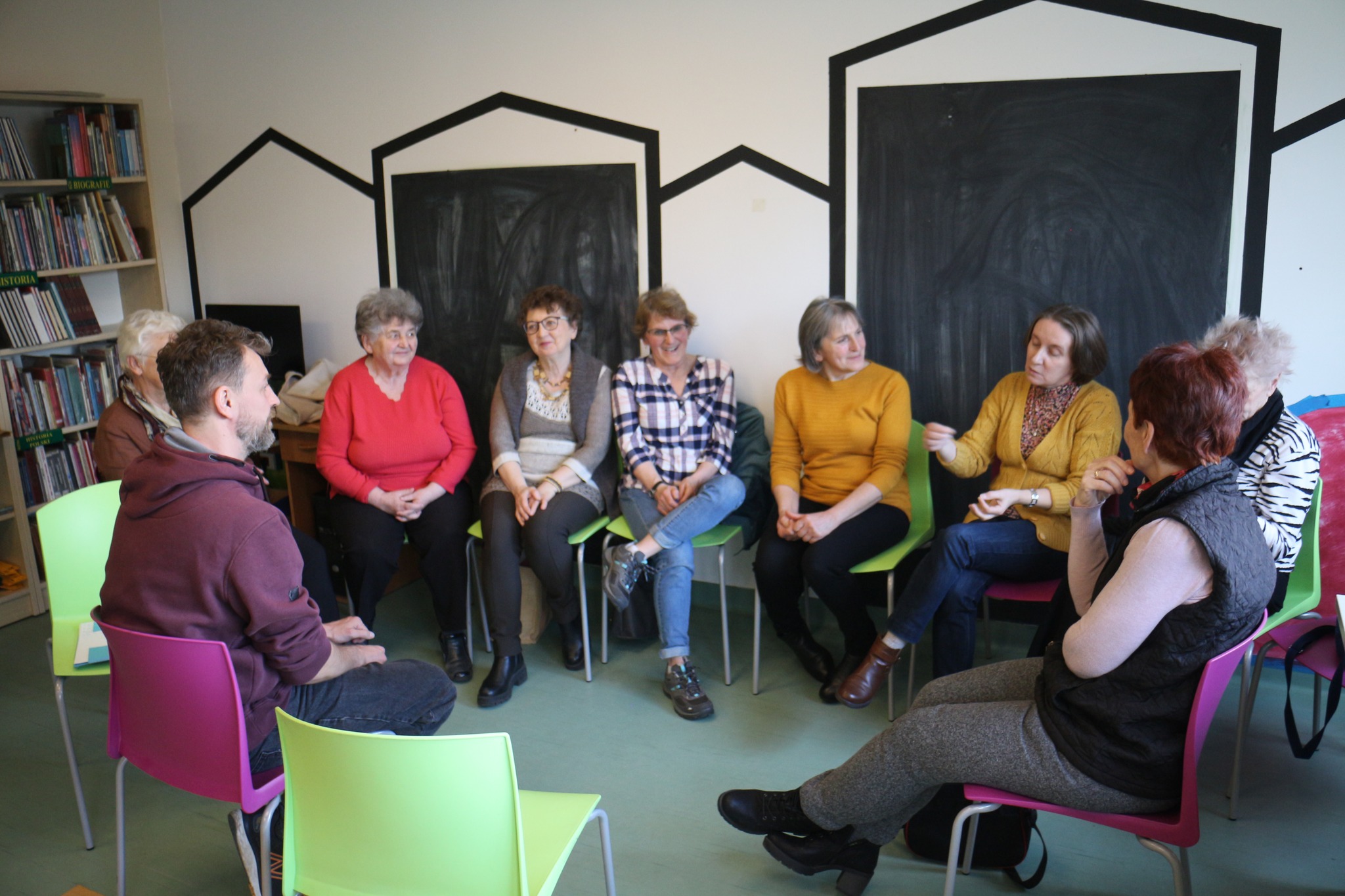 Czytelnia biblioteki. Projekt 6 stacji Coolturalnej Generacji - stacja Teatr. Grupa osób siedzi na krzesłach i dyskutuje.