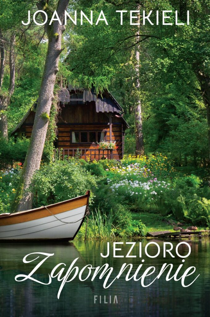 Na okładce mały drewniany domek otoczony zielenią drzew i kwiatów, jezioro a na nim fragment łódki.