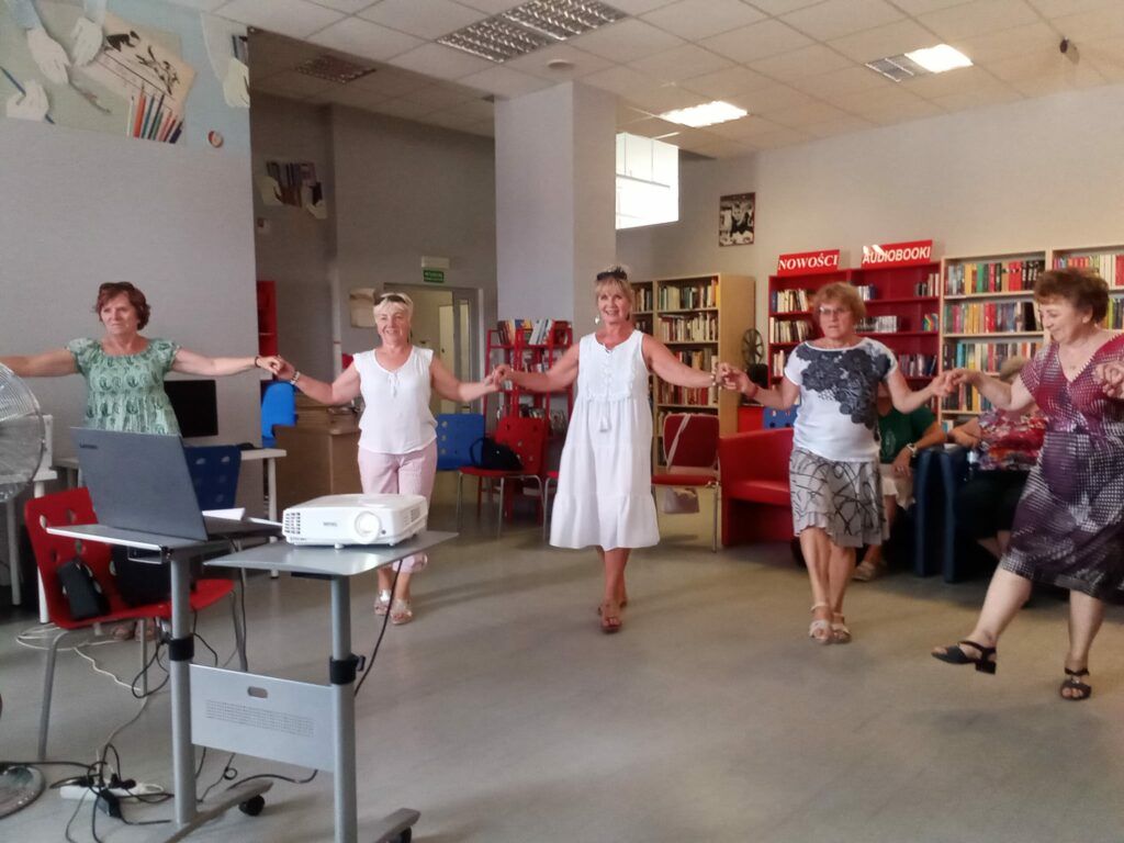 Grecja - Kobiety trzymają się za ręce i tańczą grecką Zorbę