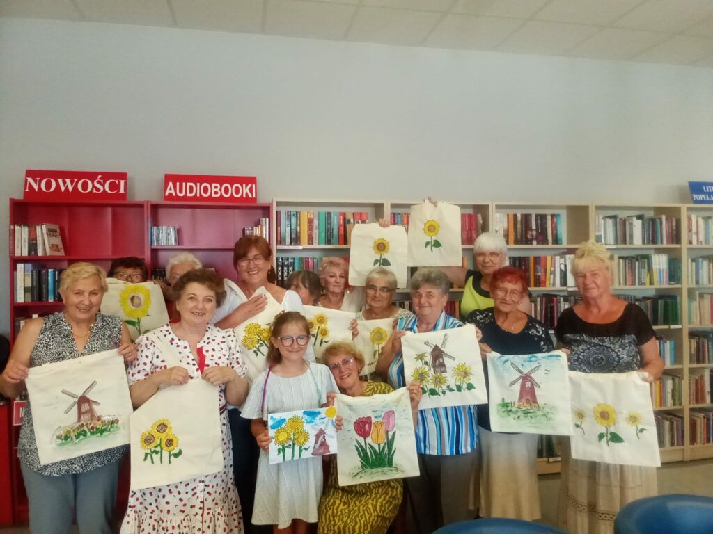 Holandia - Grupa pań prezentuje płócienne torby pomalowane w słoneczniki, tulipany i wiatraki