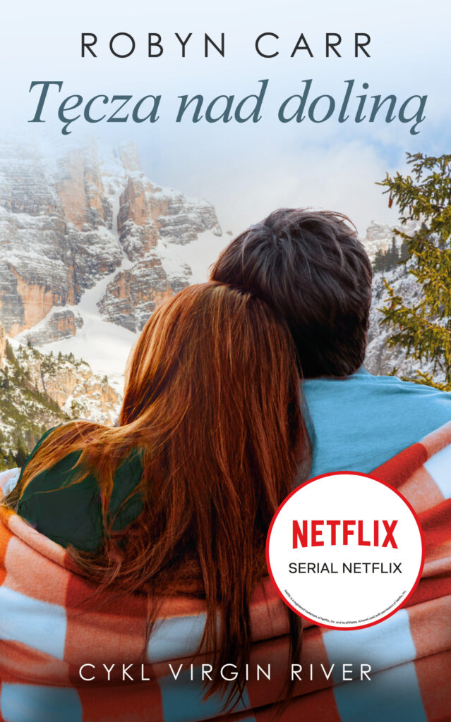 Na okładce przytuleni, odwróceni tyłem i okryci kocem w biało-czerwoną kratę kobieta i mężczyzna. W tle góry w śniegu