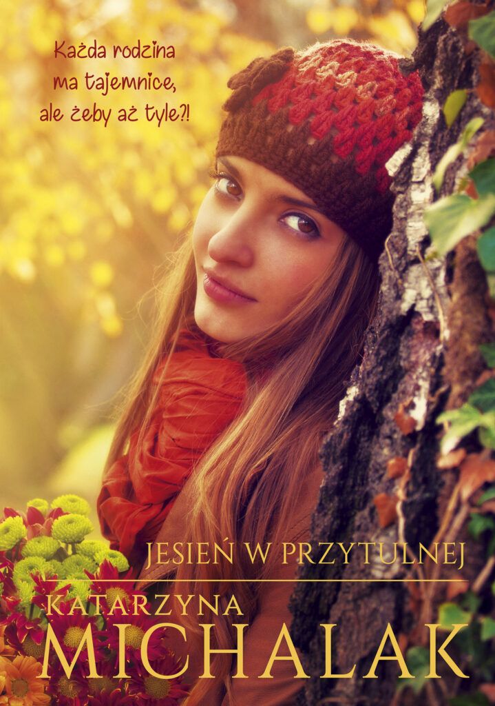 Na okładce patrząca wprost kobieta w pomarańczowo-brązowej czapce, brązowym płaszczu, z jesiennymi kwiatami w dłoniach.